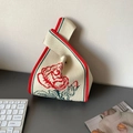 Knitted wrist knot bag in cream white featuring red rose embroidery and floral pattern - Big Red Rose Style