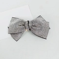 Close-up of a sparkling silver rhinestone bow hair clip on a sleek black base - 10cm Large Cross White Rhinestone