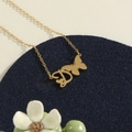 Gold stainless steel butterfly necklace with letter D pendant on a blue velvet pad - Gold D