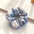 Blue and yellow plaid floral scrunchie on a book with soft natural lighting - JK Ice Cream