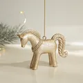 Golden glitter horse Christmas ornament hanging on a tree with a warm festive glow - Pony
