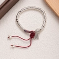 Macro detail of silver bead bracelet with handmade red cord, turtle and mask charms - Silver Red-Turtle Shell Mask