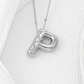 Close-up of silver balloon style letter P pendant with puffy metal texture on fine chain - Letter P Pendant