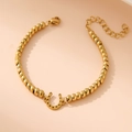 Detail of 18K gold-plated beaded bracelet with horseshoe pendant and lobster clasp - Horseshoe / Gold