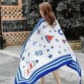White nautical shawl with anchor and lighthouse patterns, styled as a summer beach wrap - Blue Anchor Pattern