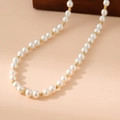 Detalle de perlas blancas y cuentas de acero inoxidable doradas en un collar elegante - 8mm / Dorado