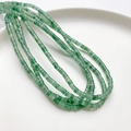 Filo di perline cilindriche in aventurina verde 4x2mm su un piatto di ceramica bianca - Aventurina verde