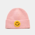 Détail d'un bonnet en maille rose avec écusson smiley jaune et texture côtelée - Rose Clair