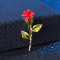 Elegant red rose brooch with green leaves and gold stem on a luxury jewelry box - Red Rose