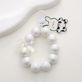 Macro shot of pearl beaded keyring with a cow pattern bunny and transparent bow charm - K1771 Mermaid White Beaded Bear
