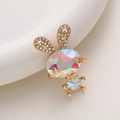 Dettaglio di una spilla a forma di coniglio dorato con strass arcobaleno luccicanti - Coniglio di Gemma / Coniglio Arcobaleno AB