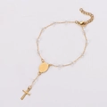 Detail of gold rosary bracelet with crystal beads, religious medallion and cross charm - 17+3cm / Clear