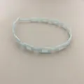 Detail of light blue chain-link headband with smooth resin finish and minimalist design - Blue