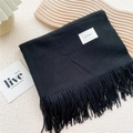 Detail of black winter scarf featuring fringe edges and white self-service woven label - Black