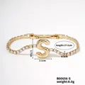 Gold-tone tennis bracelet featuring zircon studs and a stylized letter S pendant charm - Letter S