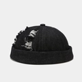 Detailopname van zwarte denim docker pet met vintage versleten gescheurde gaten - Verstelbaar / Gescheurde Zwarte Denim