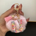 Pink pompom keychain with a clear resin letter U filled with colorful heart sequins - Letter U