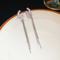 Elegante zilveren kwastjes oorbellen met zirkonia studs op een wit keramisch bord - Zilver (Zilveren pin)