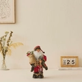 Babbo Natale in piedi con vestito rosso e oro, sacco di regali e lanterna decorativa - 30cm