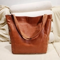 Dettaglio della borsa tote vintage in pelle marrone con tasca anteriore sul divano - Tipo standard / Marrone
