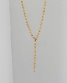 Detalle de un collar minimalista de cuentas doradas con cuentas pulidas y cierre de metal robusto - Dorado