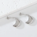 Detailed view of silver thick C-shape crescent earrings on a minimalist stone background - 1184 Steel Color New Moon