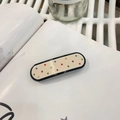 Pince à cheveux en acétate beige avec bordure noire et strass sur une page de livre - Pince À Ressort Color-Block / Environ 6,5 cm