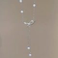 Detailansicht der silbernen Y-Kette mit Perlen und einem funkelnden Diamant-Schleifenanhänger - Silberne Schleife
