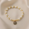 Detail of beaded bracelet with faux pearls, gold beads, and a black zircon paved pendant - Black Zirconia Round Disc Pendant