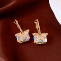Détail de boucles d'oreilles papillon dorées avec cristal rectangulaire sur velours brun - Or (Tige en Argent S925)