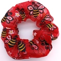 Detail of red mesh scrunchie featuring festive bee and flower prints on fabric - 520 Bee