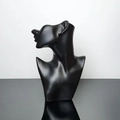 Detail view of matte black mannequin head display for elegant earring presentation - Black