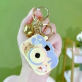 Mini camera-shaped Pompompurin keychain with golden bell and purple accent trim - Projector Camera - Yellow