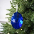 Blue faceted oval acrylic gemstone ornament hanging on a Christmas tree branch - Oval Gemstone / Blue