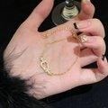 Gold plated horseshoe bracelet with sparkling zircons on a luxury dark feather background - Gold