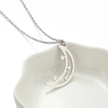 Collana chic in argento con ciondolo luna e stelle su un piatto di ceramica bianco - Color Acciaio