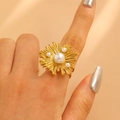 Close-up of a gold sunflower ring with pearls worn on a finger against satin background - Gold (9639)