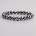 Primer plano de pulsera de perlas gris oscuro 8mm con una bola de metal plateada - Piedra de Lava Plateada