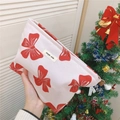 Detalle de neceser de lona con lazo rojo y etiqueta Simple Wish para cosméticos - Blanco con lazo rojo
