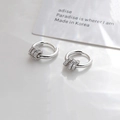 Detail van zilveren oorbellen met drie hangende ringen bezet met zirkonia steentjes - Zilver
