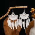 Detailed shot of ethnic silver fan earrings with leaf tassels hanging on a wood branch - Silver Fan Totem Leaf Tassel Style (E2873-6)