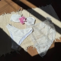 Close-up of white three-piece bikini with floral decor and lace sarong on rug - S / Off-White