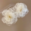 Detailed close-up of white chiffon flower earrings with golden stamen and soft petals - White