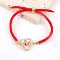Dettaglio del bracciale a cordino rosso con cuore in zirconi ed elemento Evil Eye - Rosso