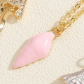 Macro shot of gold necklace with pink enamel shell pendant and zircon starfish detail - Pink Conch