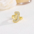 Vista macro dell'anello con lettera J dorata con zirconi micro-pave e fascia aperta - Lettera J
