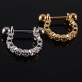 Silver and golden D-shaped cartilage piercings with zircons on a black reflective base - NO 23