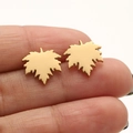 Minimalist golden maple leaf stud earrings with a brushed finish held in hand - Maple Leaf / Gold