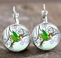 Gros plan de boucles d'oreilles cabochon en verre colibri argenté et motifs floraux noirs - Style 5
