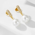 Detalle macro de pendientes de perlas doradas con microcirconitas sobre fondo blanco - Plata 925 / Dorado